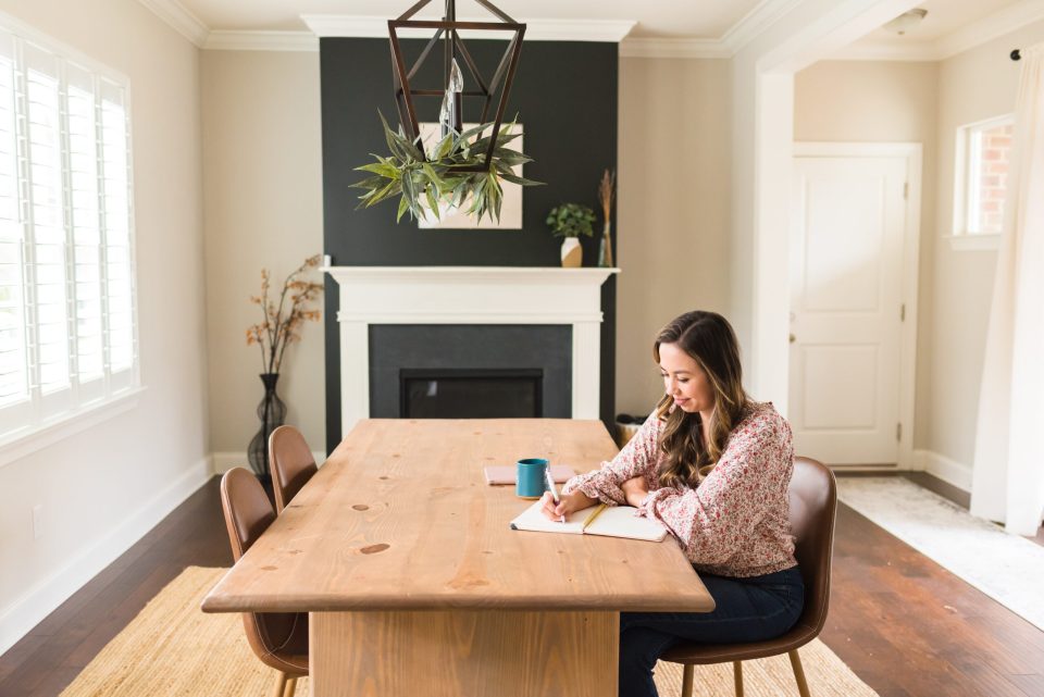 bring-faith-into-your-business-as-a-christian-business-owner sitting writing out ways to bring faith into your business as a Christian business owner