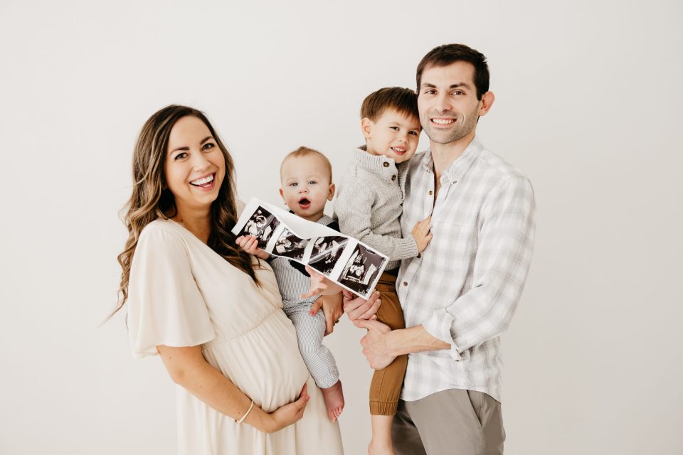 Elizabeth-McCravy-Baby-Announcement-Studio-Photos-21 closeup of family of five pregnancy announcement